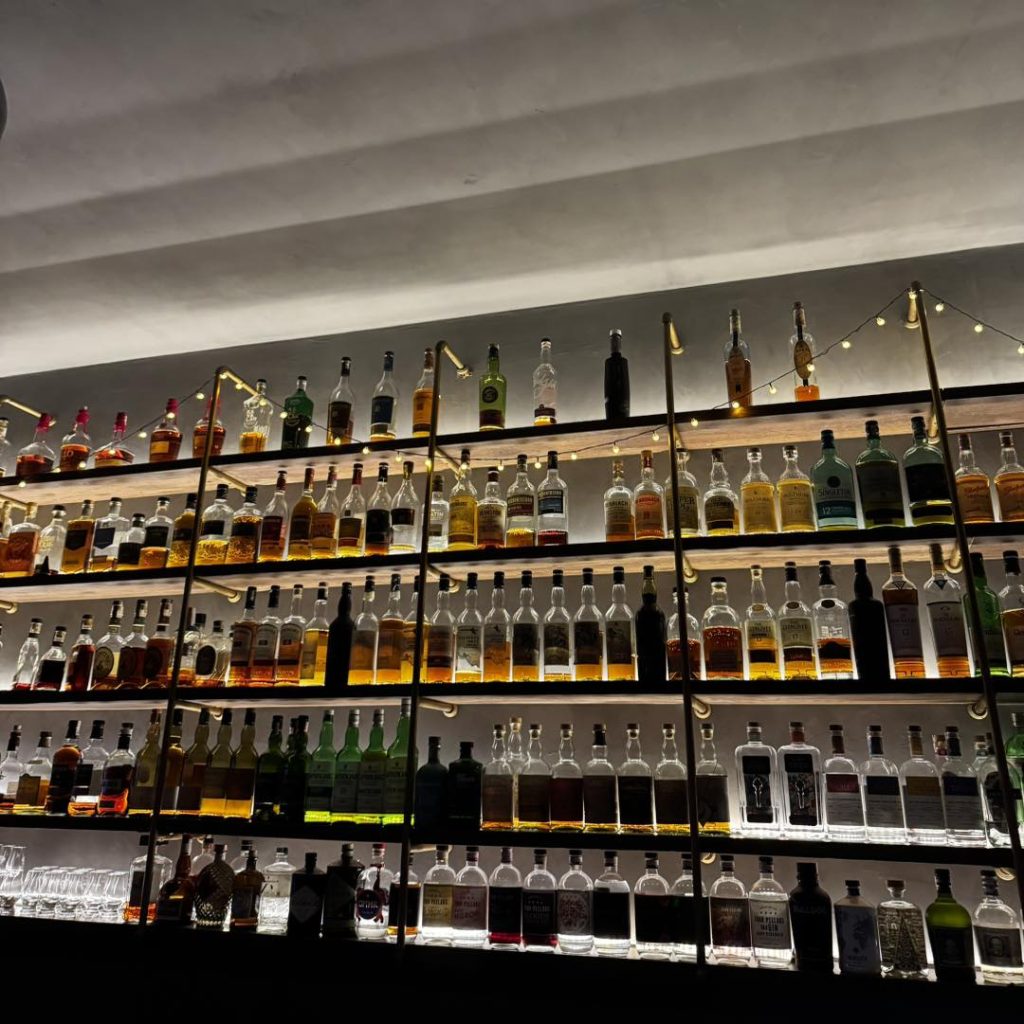 Tủ rượu whiskey đa dạng tại 86 Proof Bar với hàng trăm chai rượu cao cấp