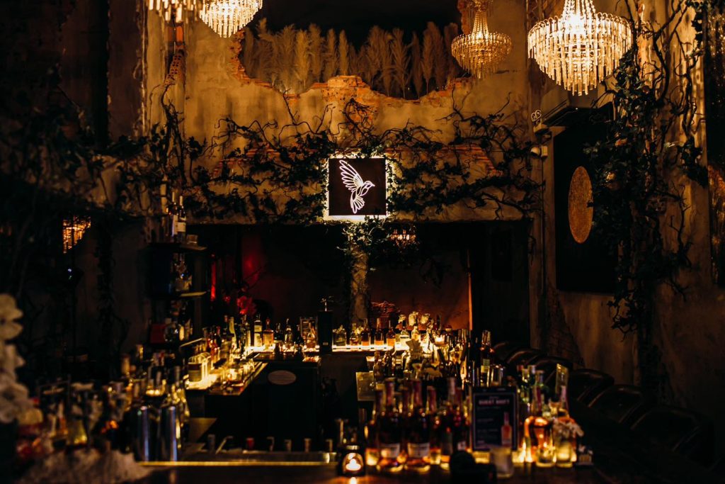 Quầy bar hình chữ nhật trung tâm Lost Birds với bartender pha chế cocktail chuyên nghiệp