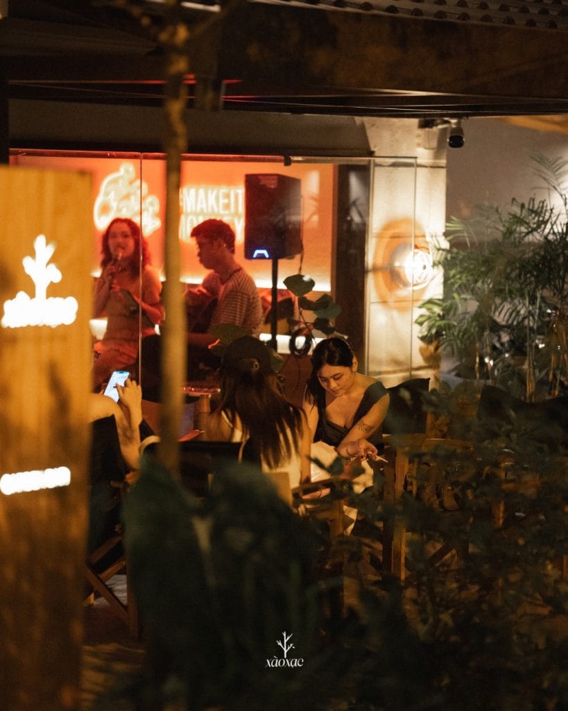 Khu vực outdoor Xào Xạc Bar với bàn ghế gỗ và không gian xanh mát