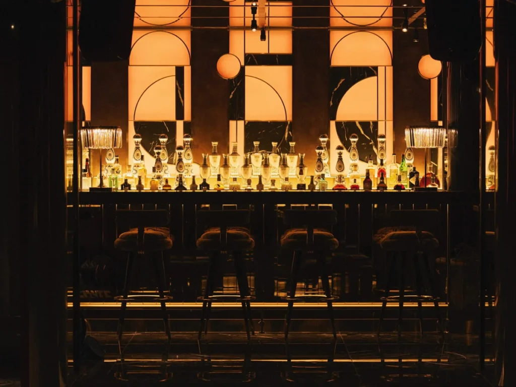 Papi Club Saigon – quầy bar với dãy chai Tequila trưng bày và ghế quầy bar